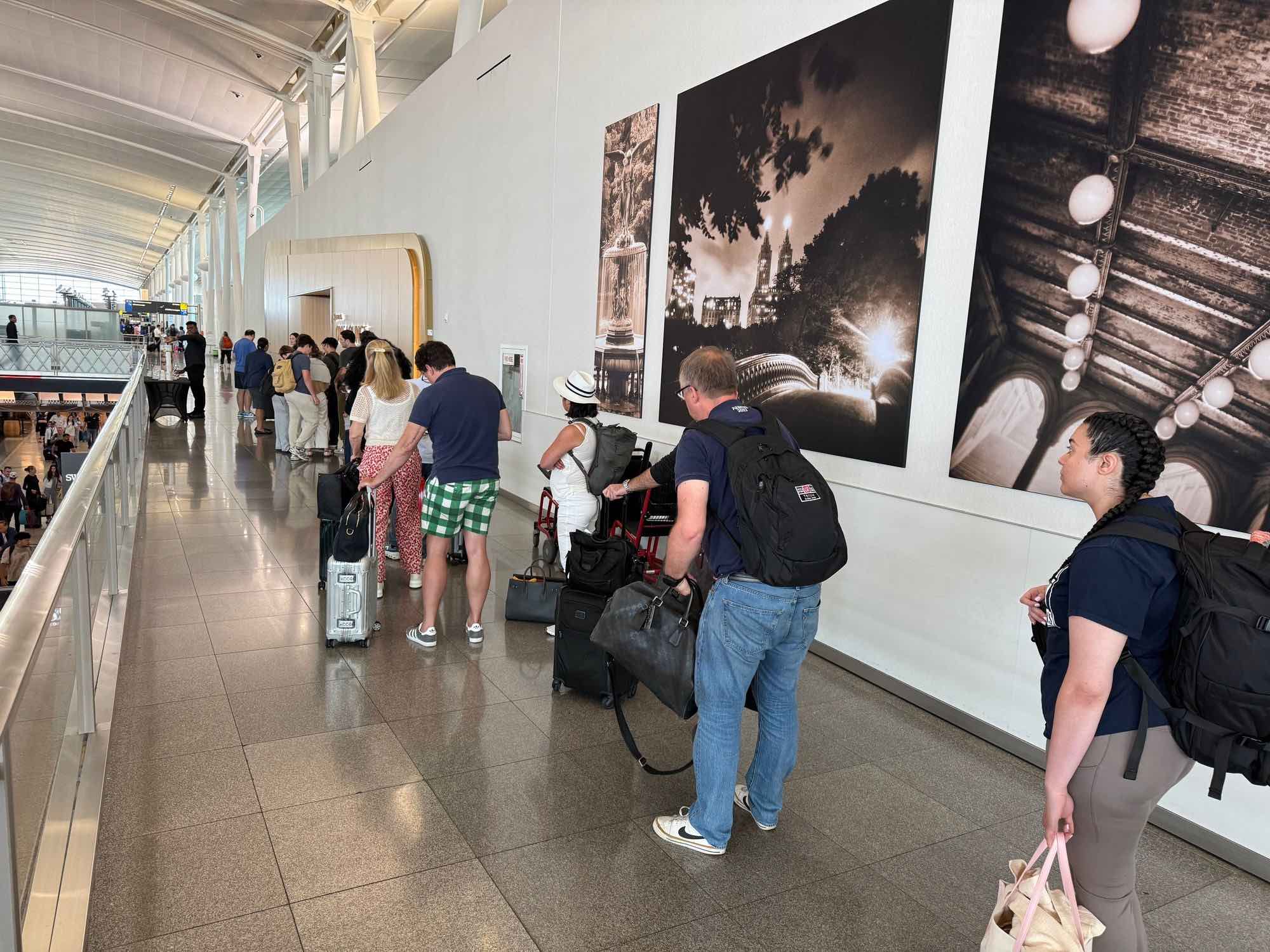 a group of people standing in a line with luggage