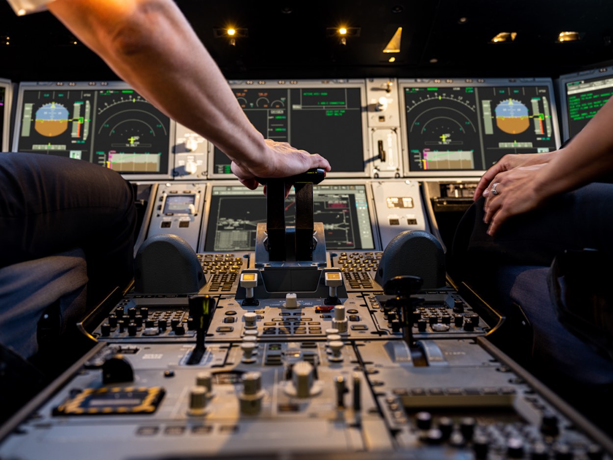 a close up of a person's hands on a control panel