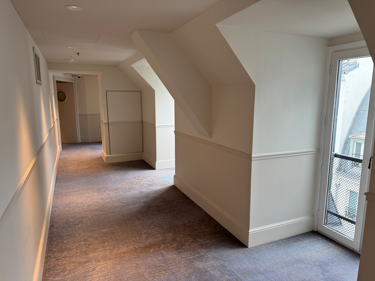 a hallway with a door and a glass door