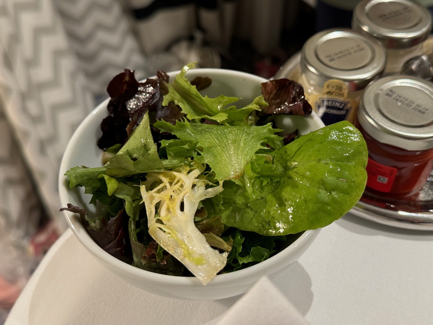 a bowl of salad with other food in the background