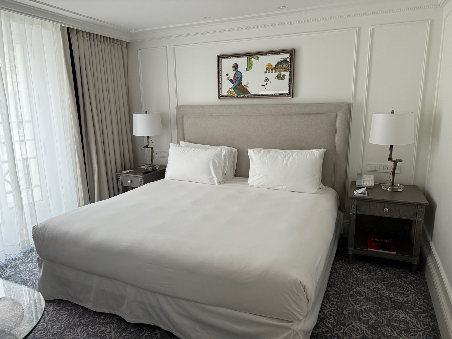 a bed with white sheets and lamps in a room