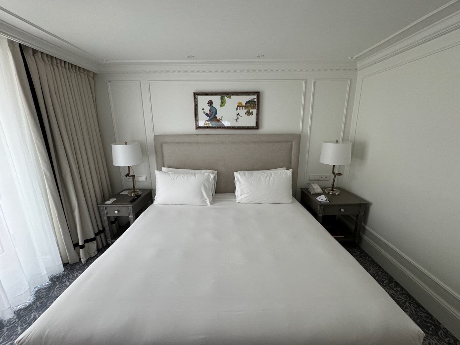 a bed with white sheets and lamps in a room