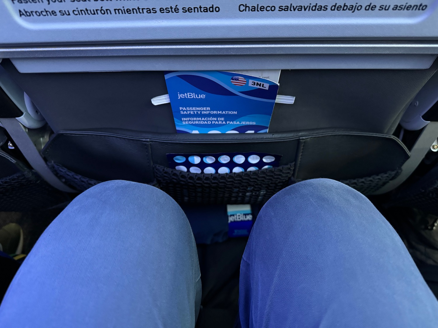 a person's legs in a seat with a pocket in the pocket