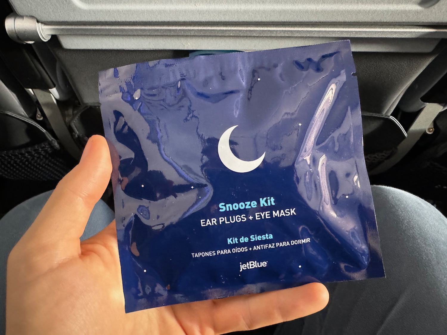 a hand holding a blue package with a moon and white text