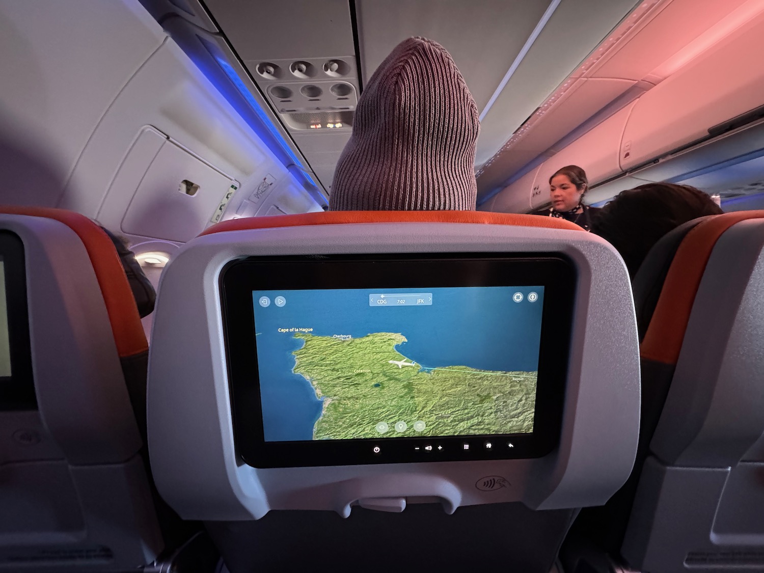 a person in a beanie on a seat in an airplane