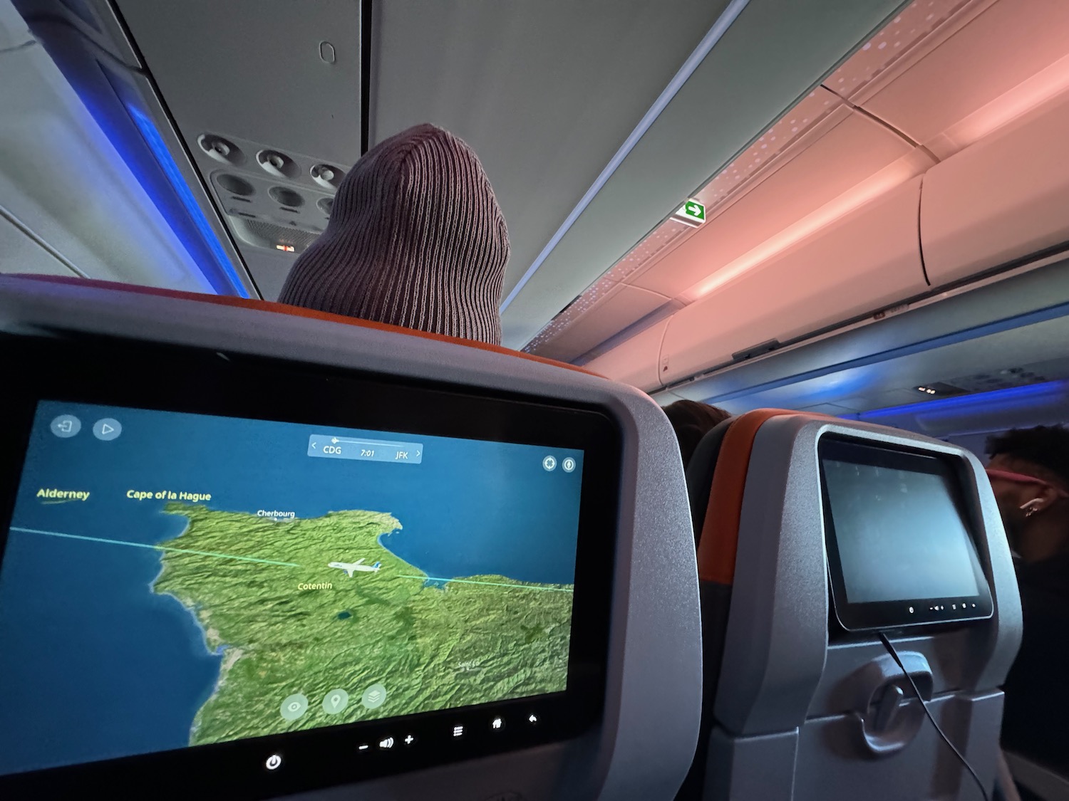 a person in a mask looking at a map on an airplane