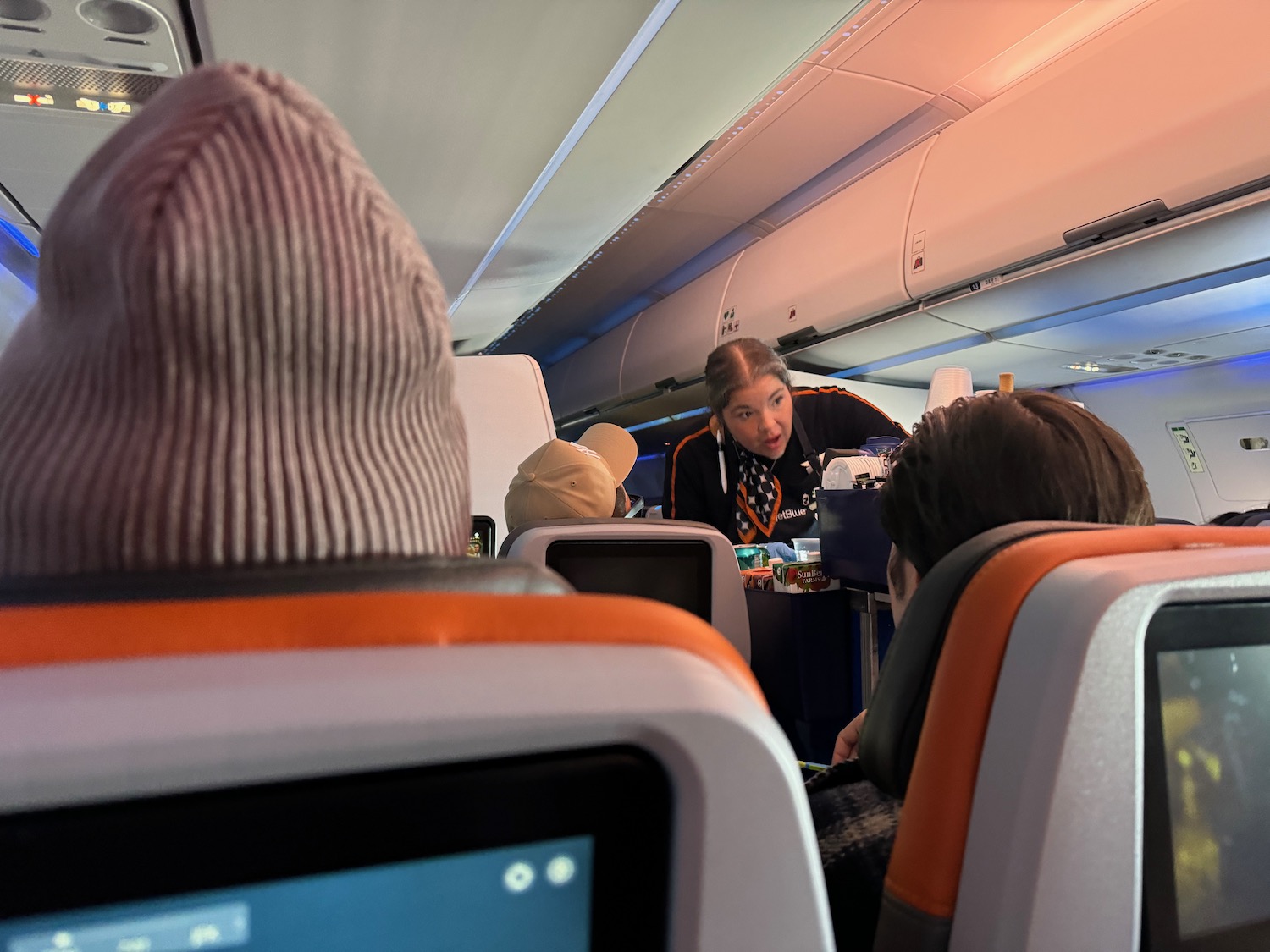 a woman sitting at a table with people in the back