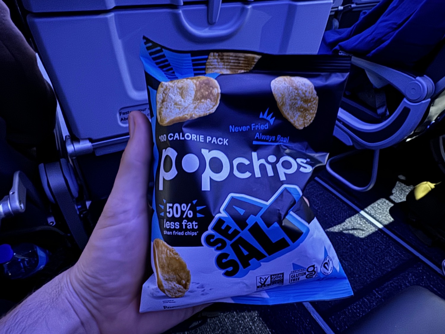 a hand holding a bag of chips
