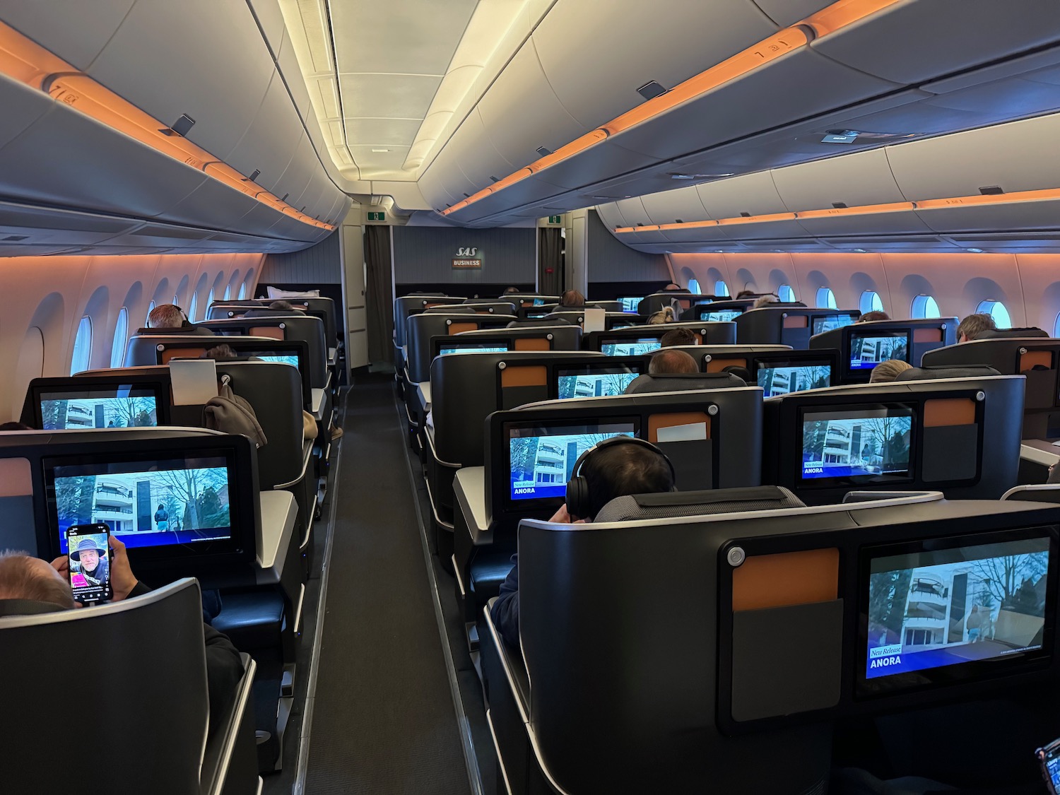 a group of people sitting in an airplane with computers