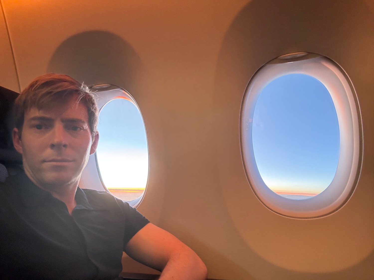 a man sitting in an airplane with two windows