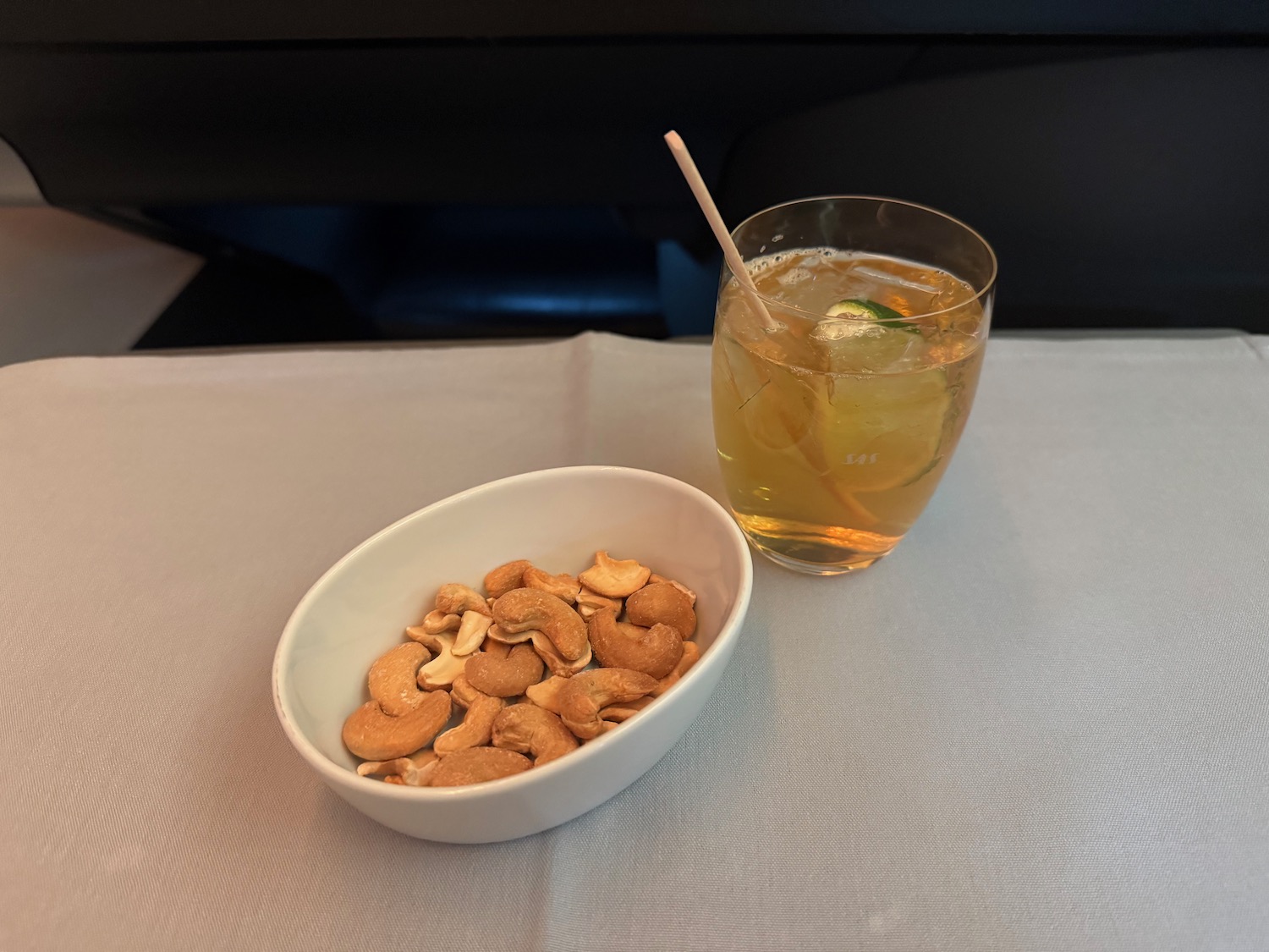 a bowl of cashews and a glass of juice
