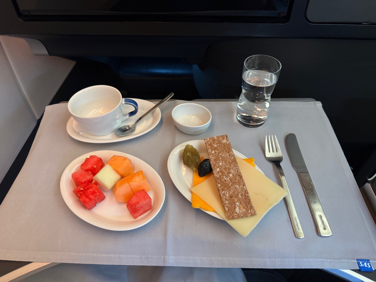 a plate of food and a glass of water on a tray