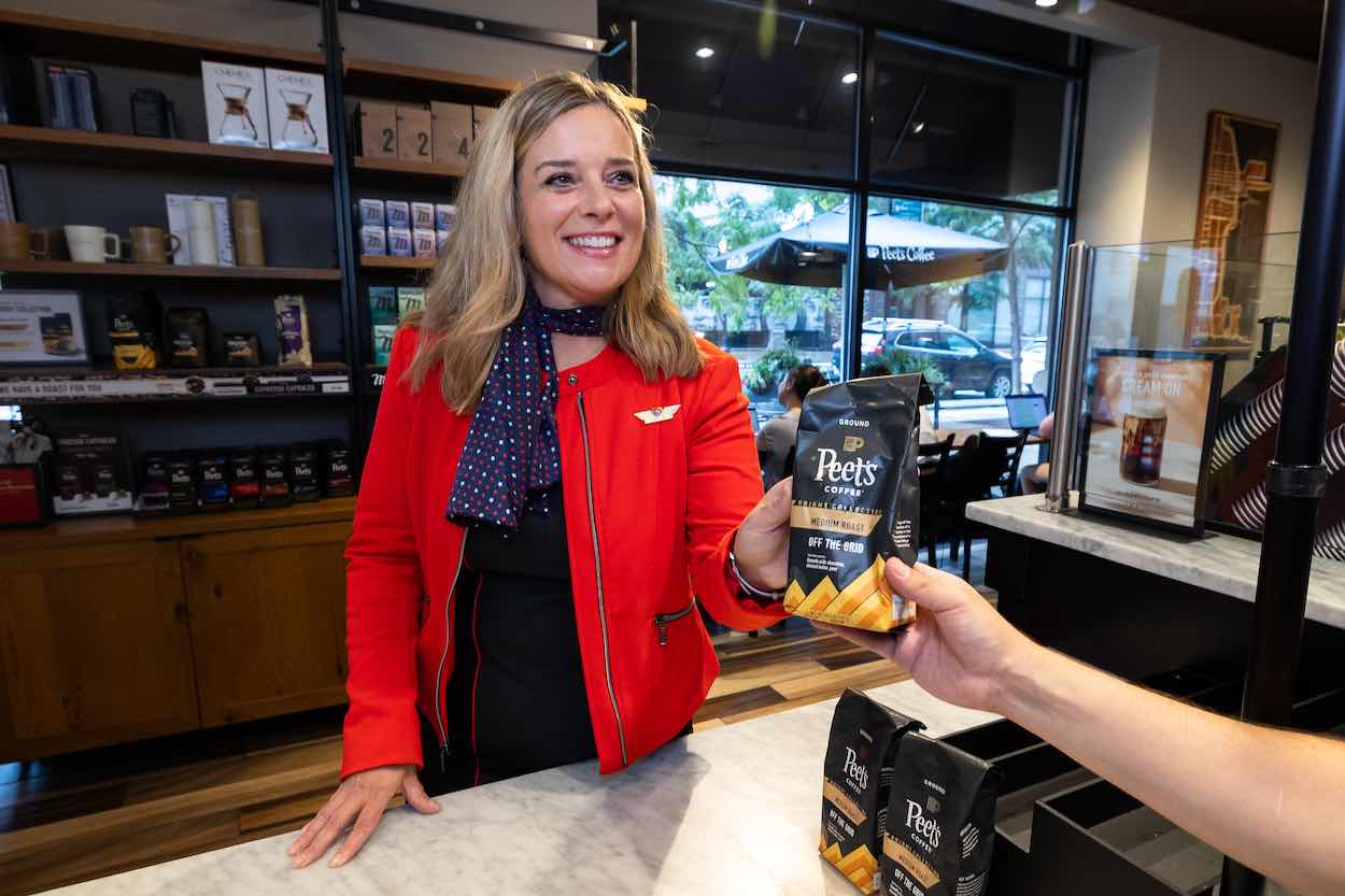 a woman handing a bag of coffee to a customer