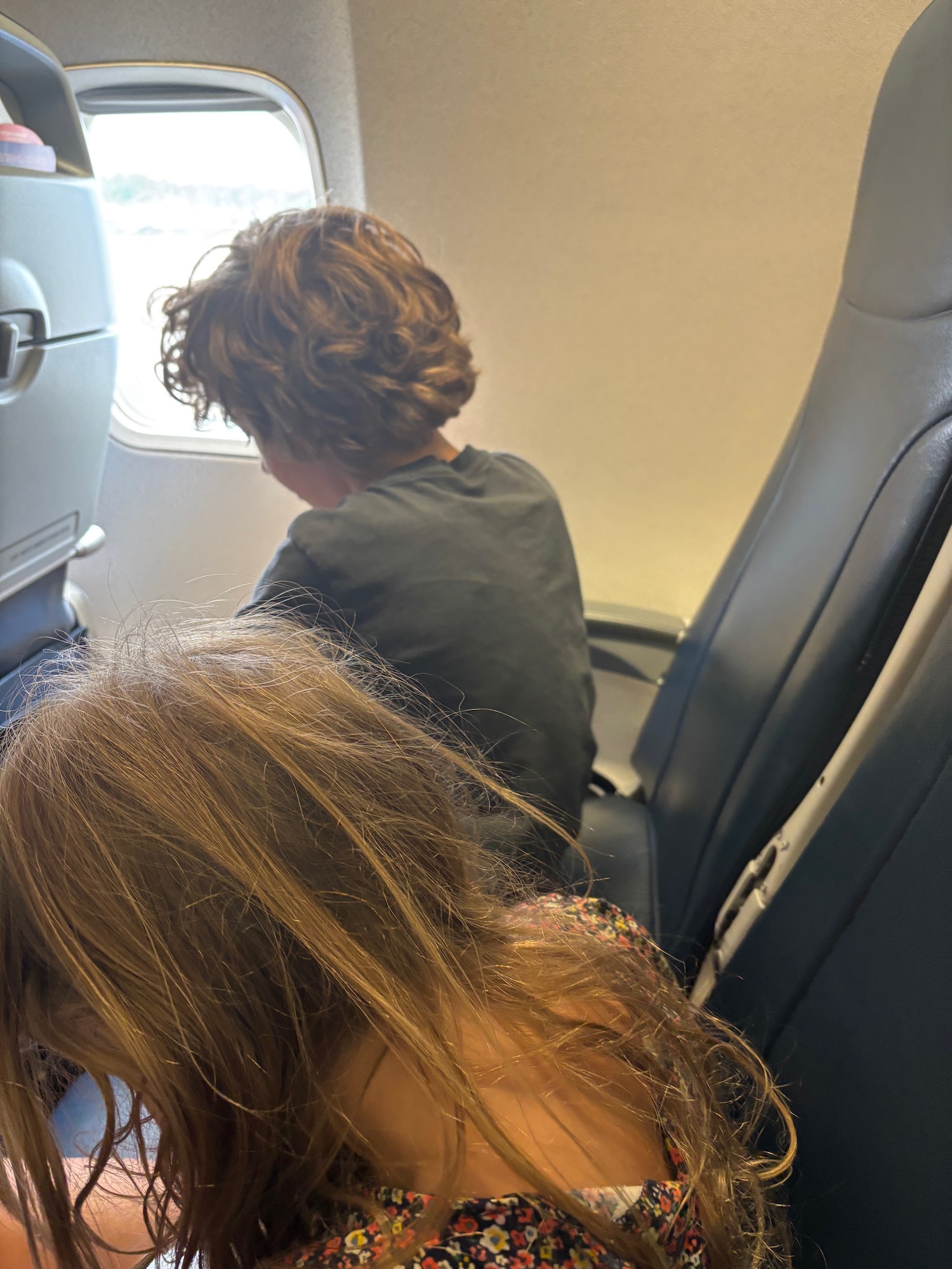a boy and girl sitting in an airplane