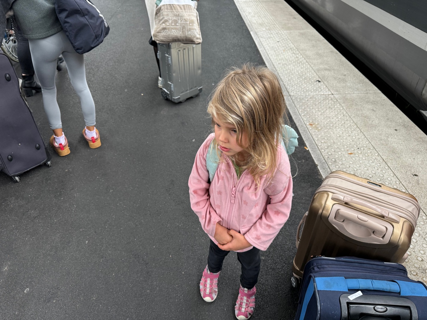 a girl standing next to luggage
