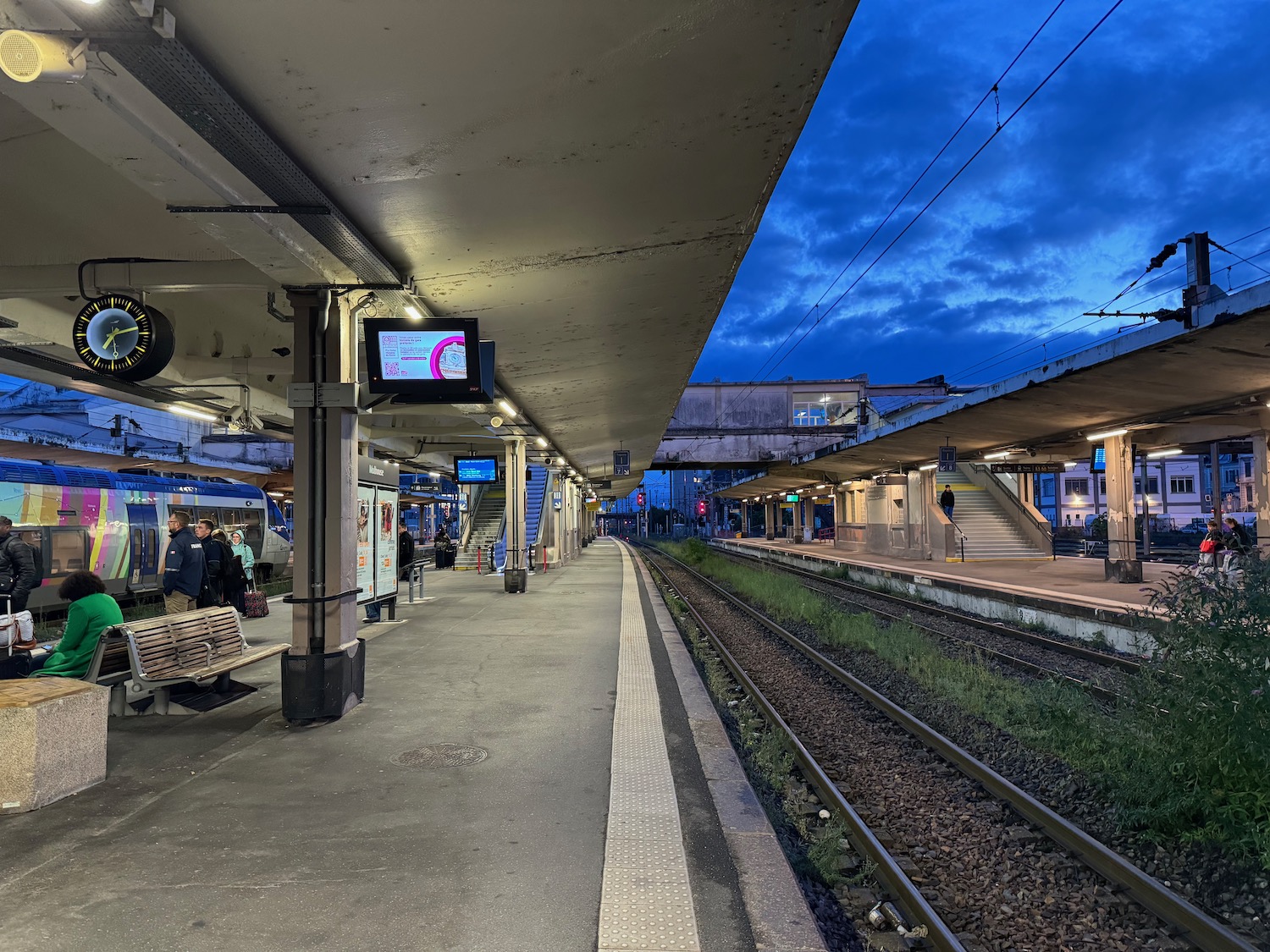 a train station with people waiting for the train