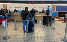 people standing in front of a desk with luggage