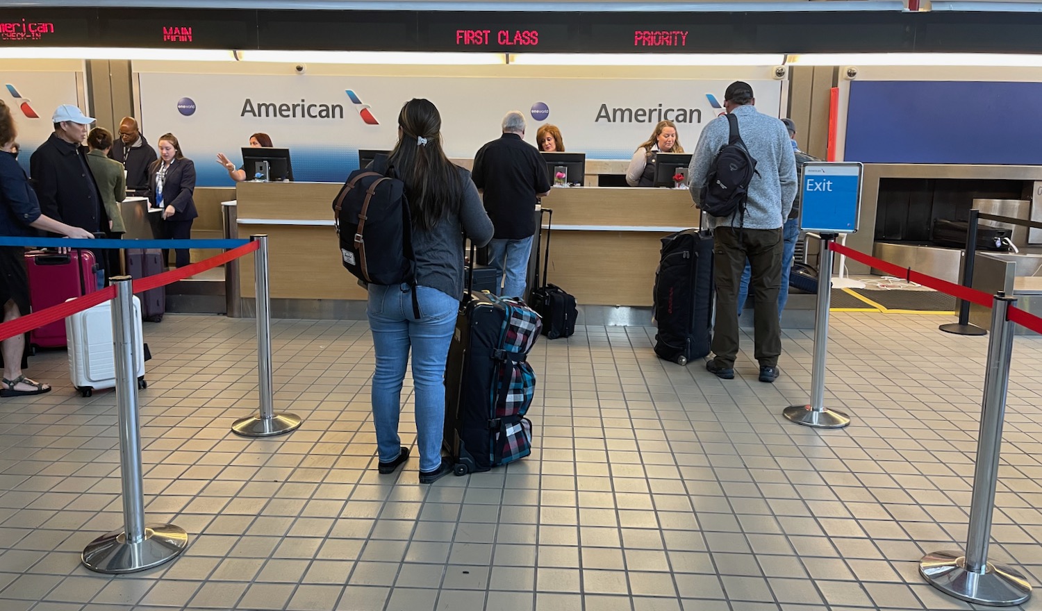 people standing in front of a desk with luggage