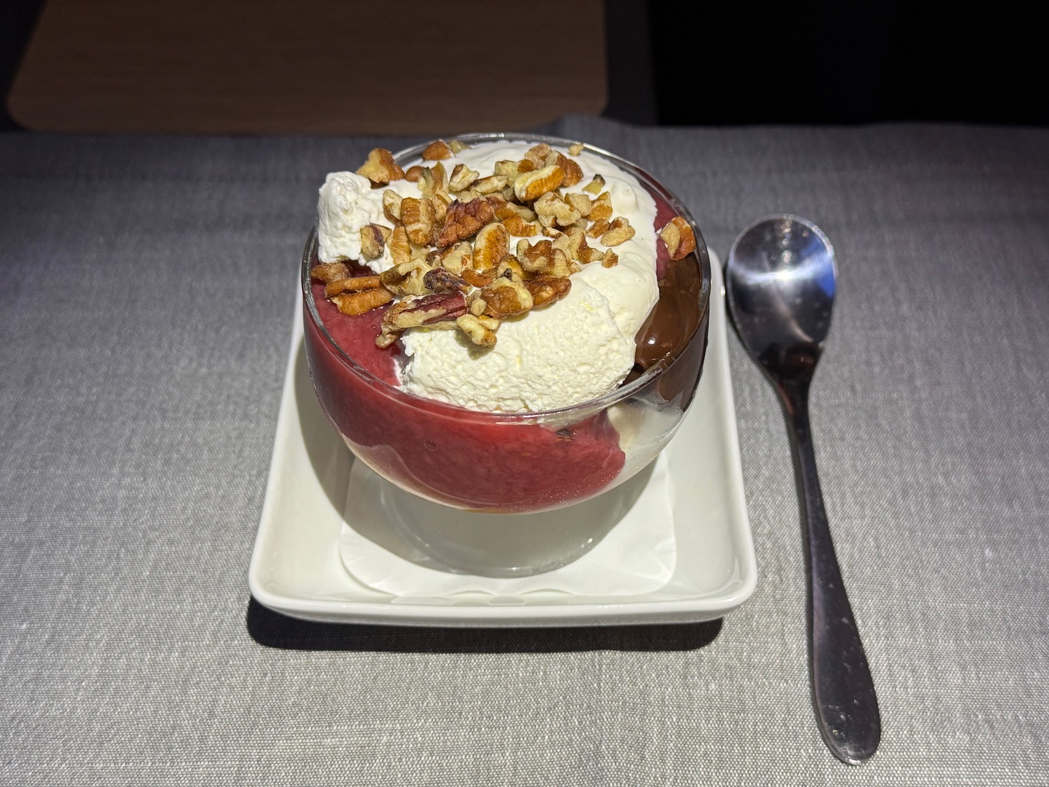a bowl of ice cream with nuts and a spoon