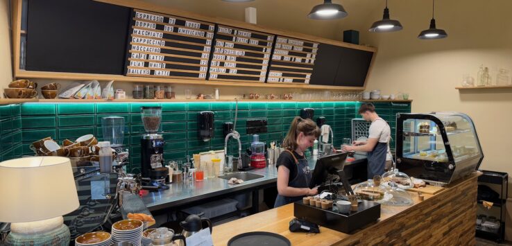 a woman standing at a counter in a coffee shop