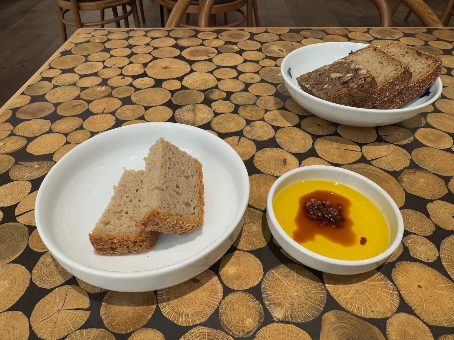 a bowl of bread and a bowl of oil on a table