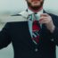 a man in a suit and tie holding a belt