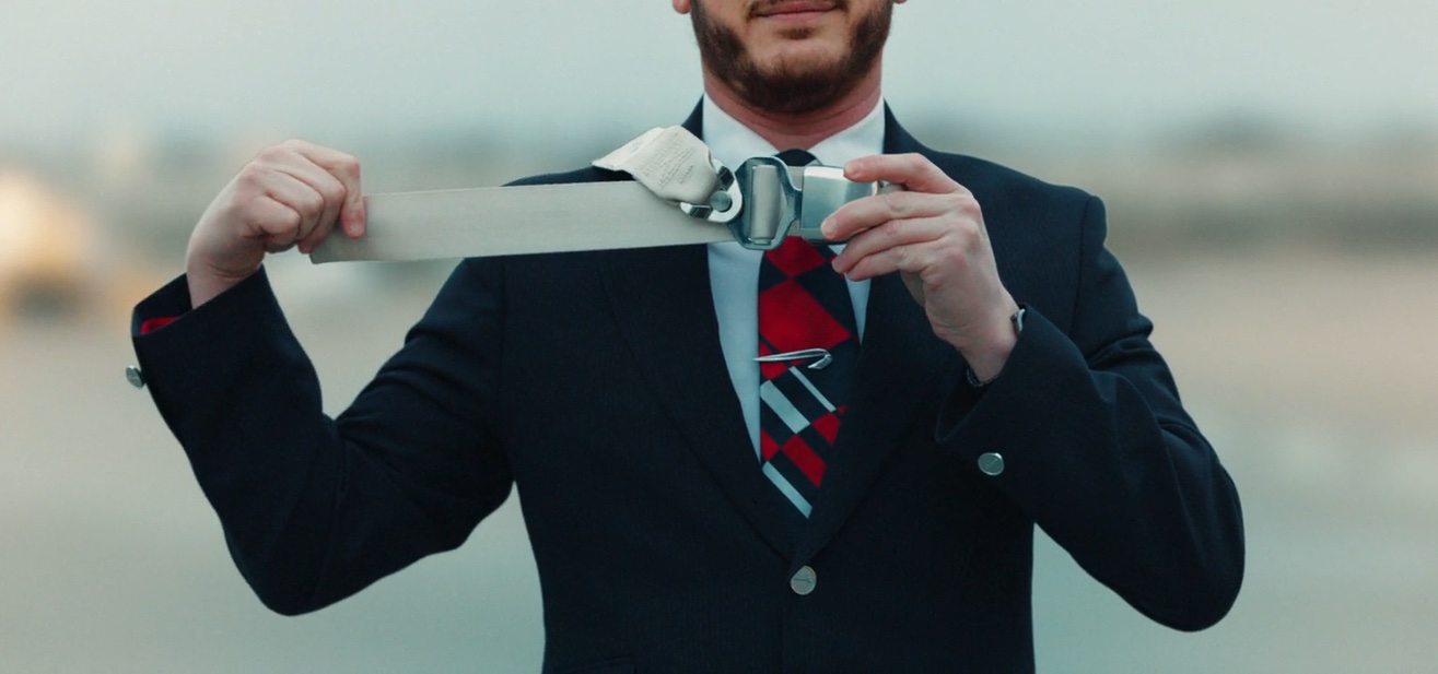 a man in a suit and tie holding a belt