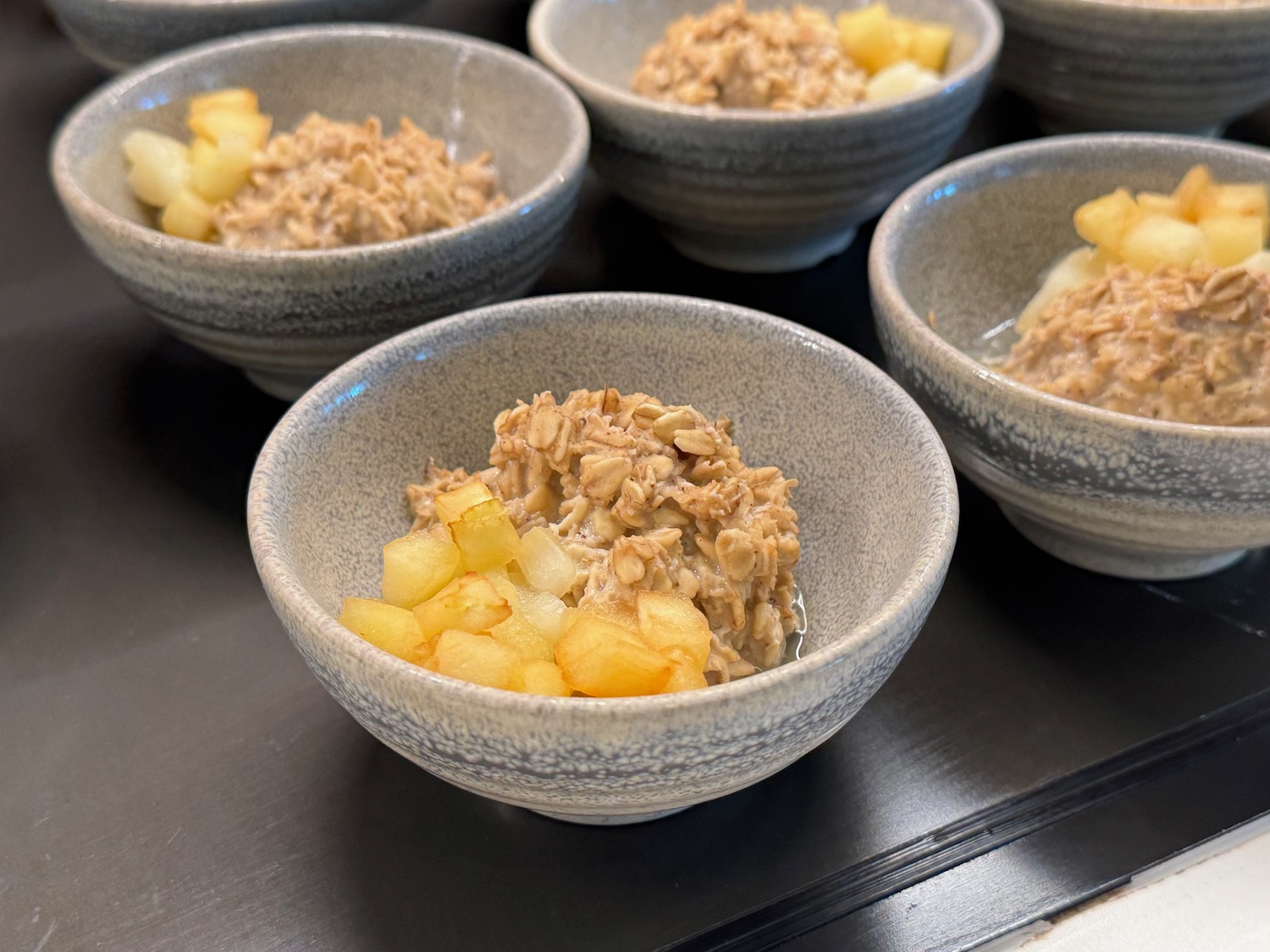 a group of bowls of oatmeal with fruit