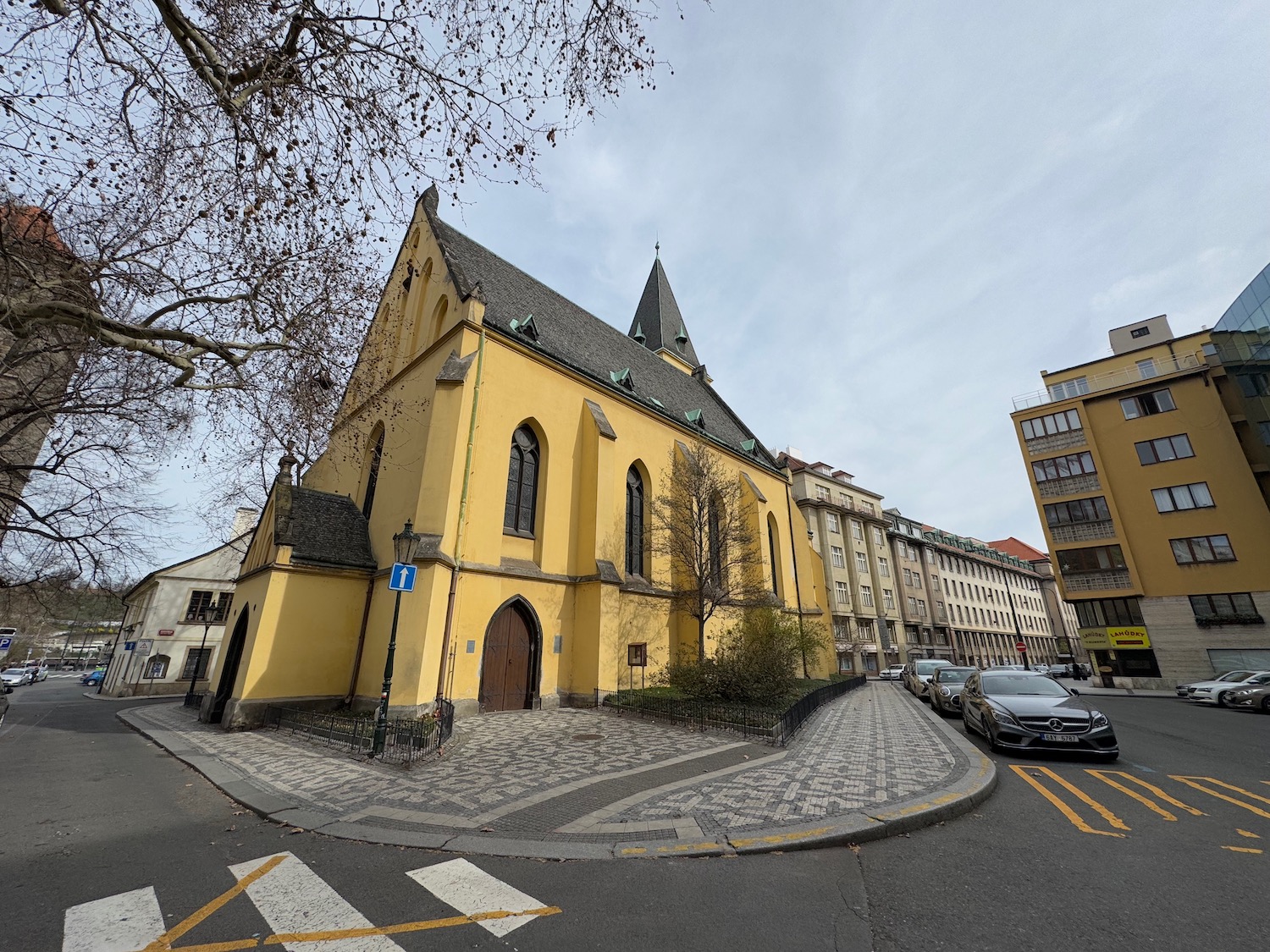 a yellow building with a steeple and a street corner