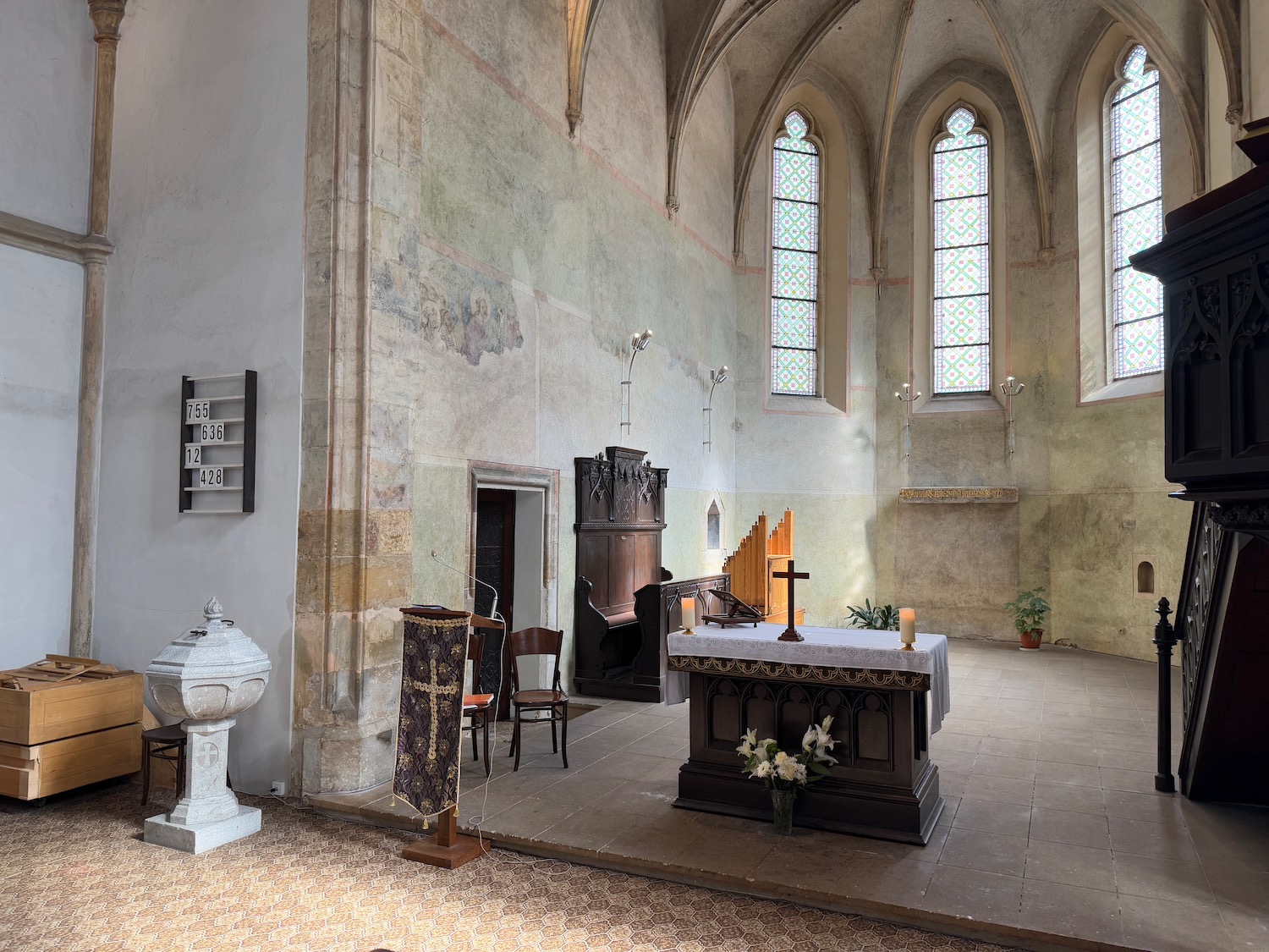 a church with a stone wall and a stone altar