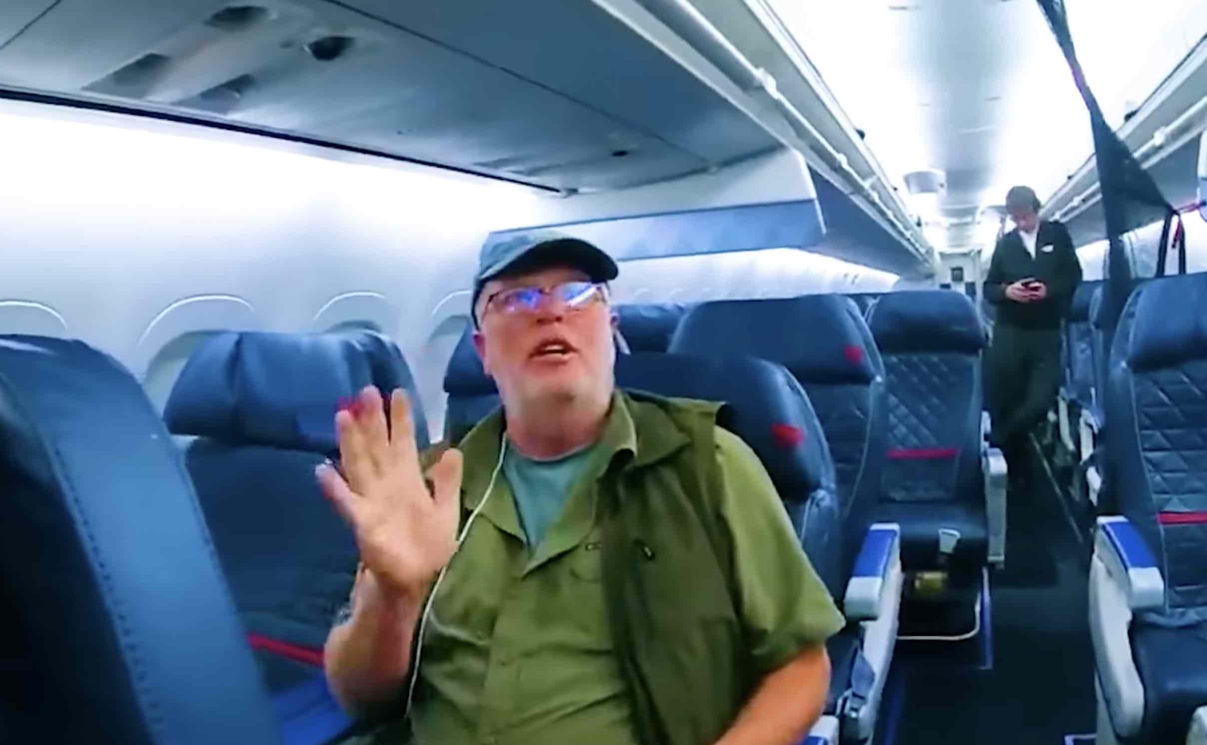 a man in a hat and glasses waving