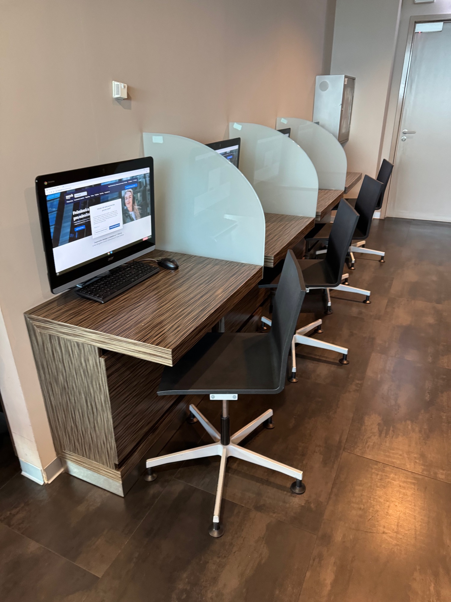a computer screen on a desk with chairs