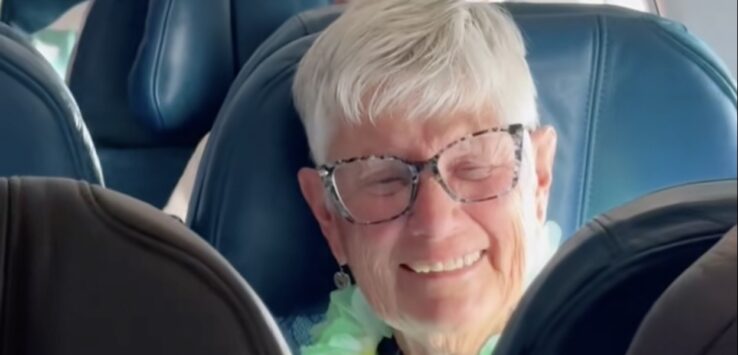 an older woman sitting in a plane