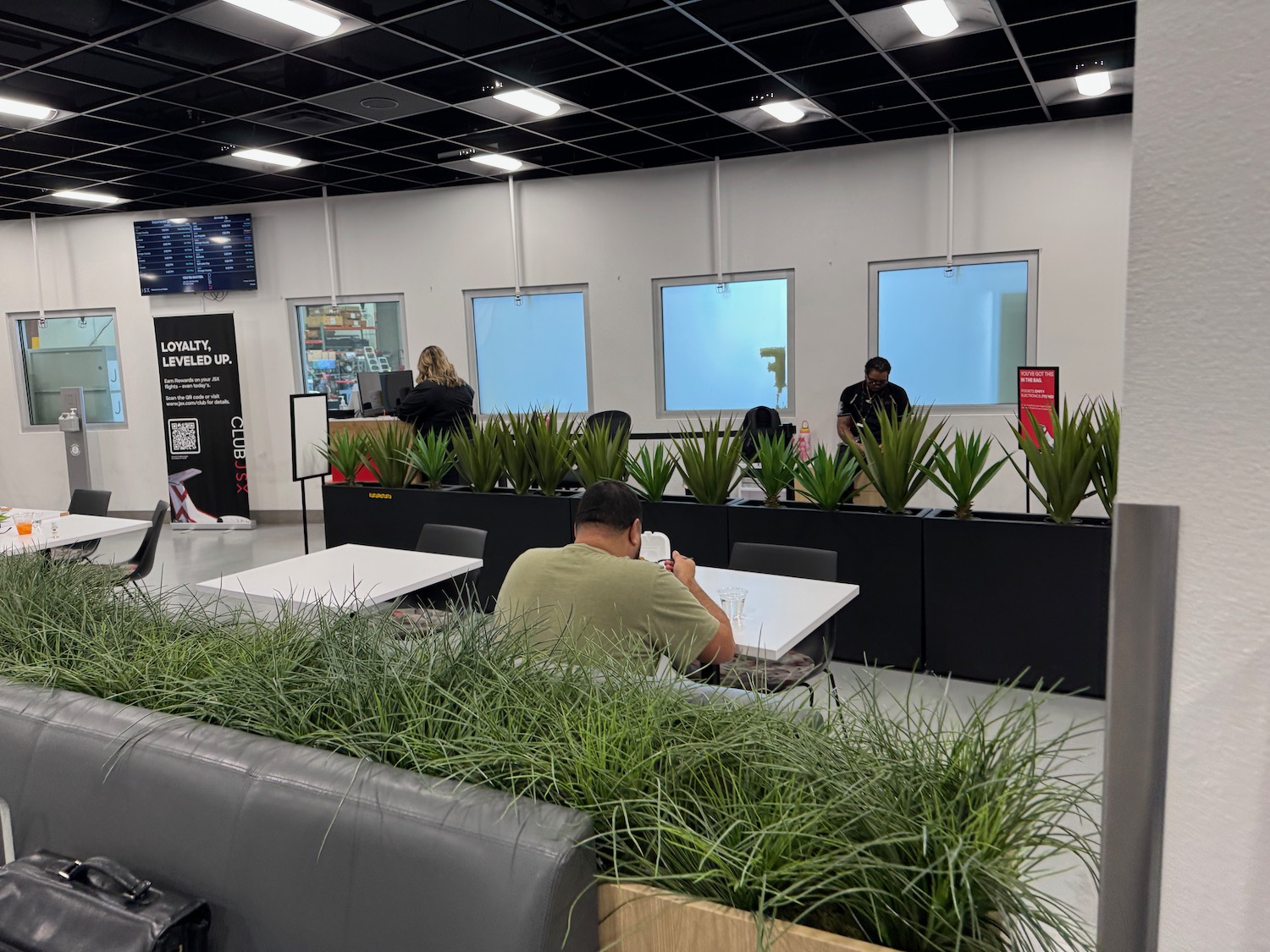a man sitting at a table in a room with plants