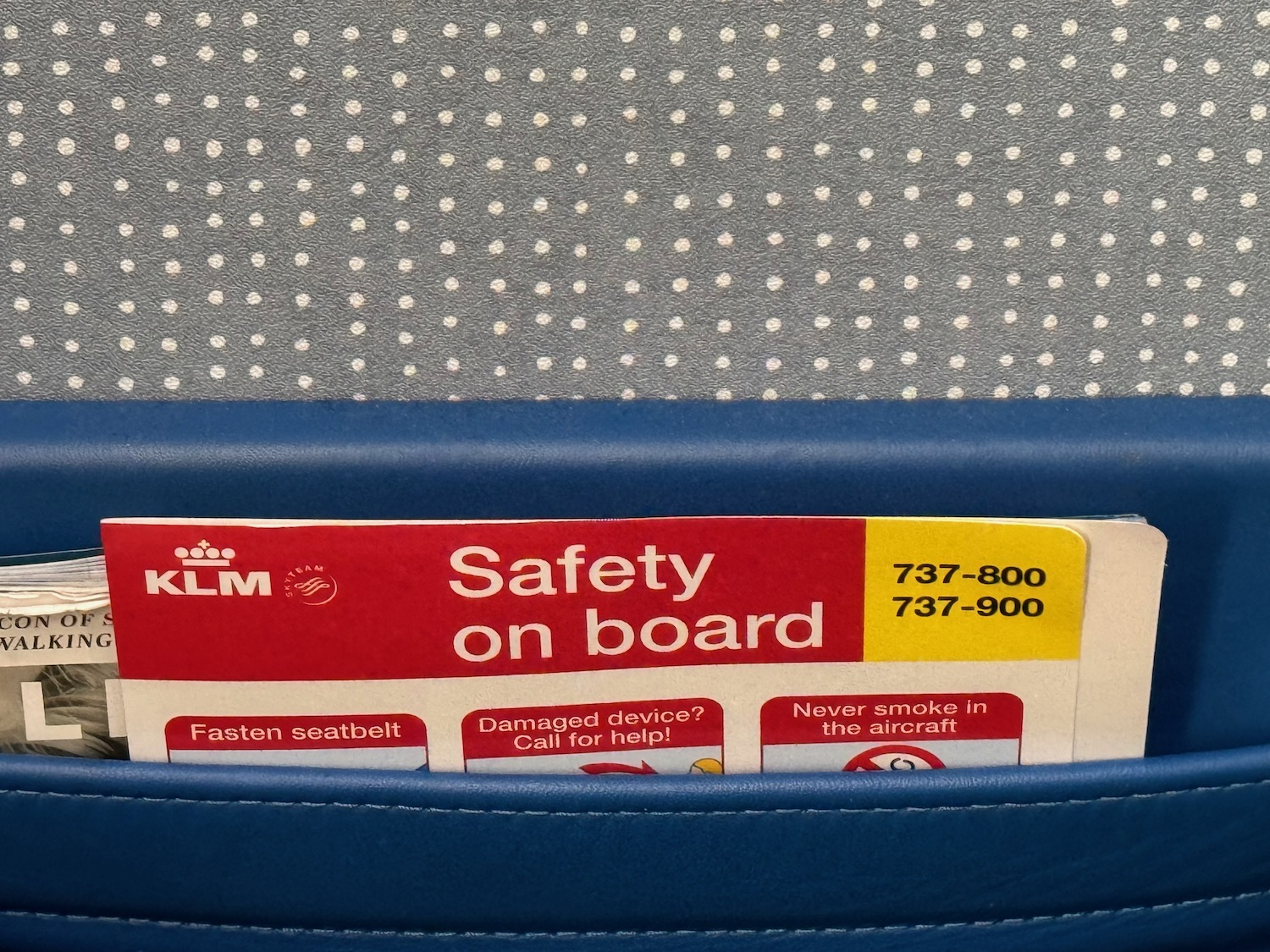 a safety card in a blue seat