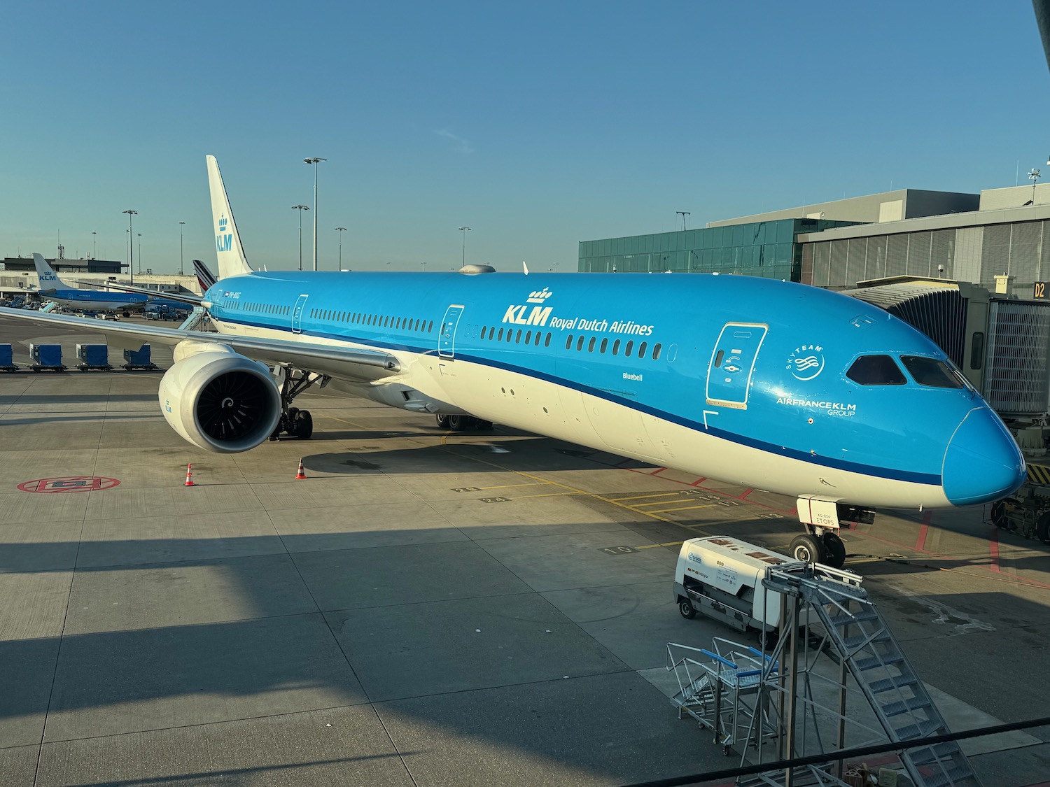a blue and white airplane at an airport