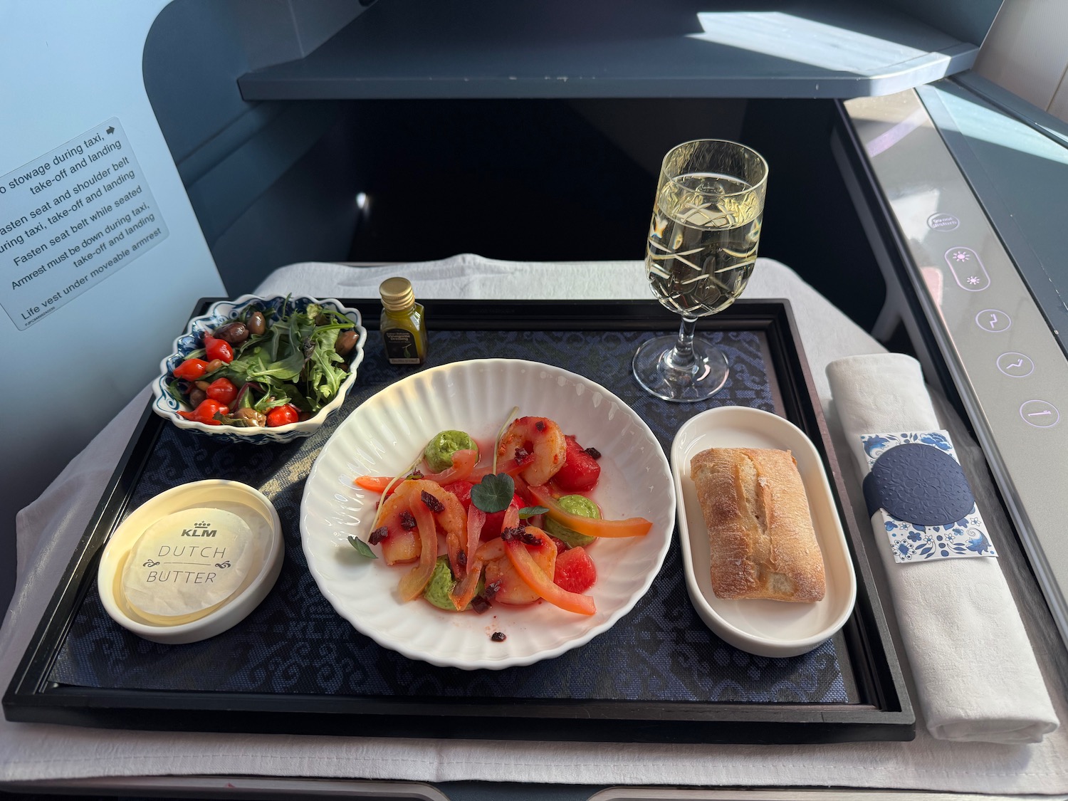a tray with food and a glass of wine