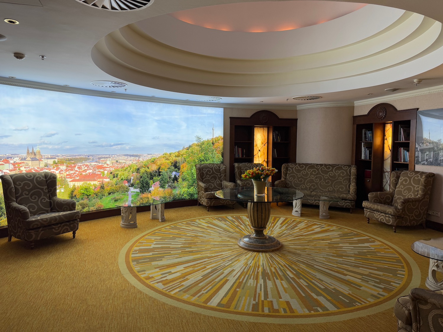 a room with a circular rug and a table with chairs and a window