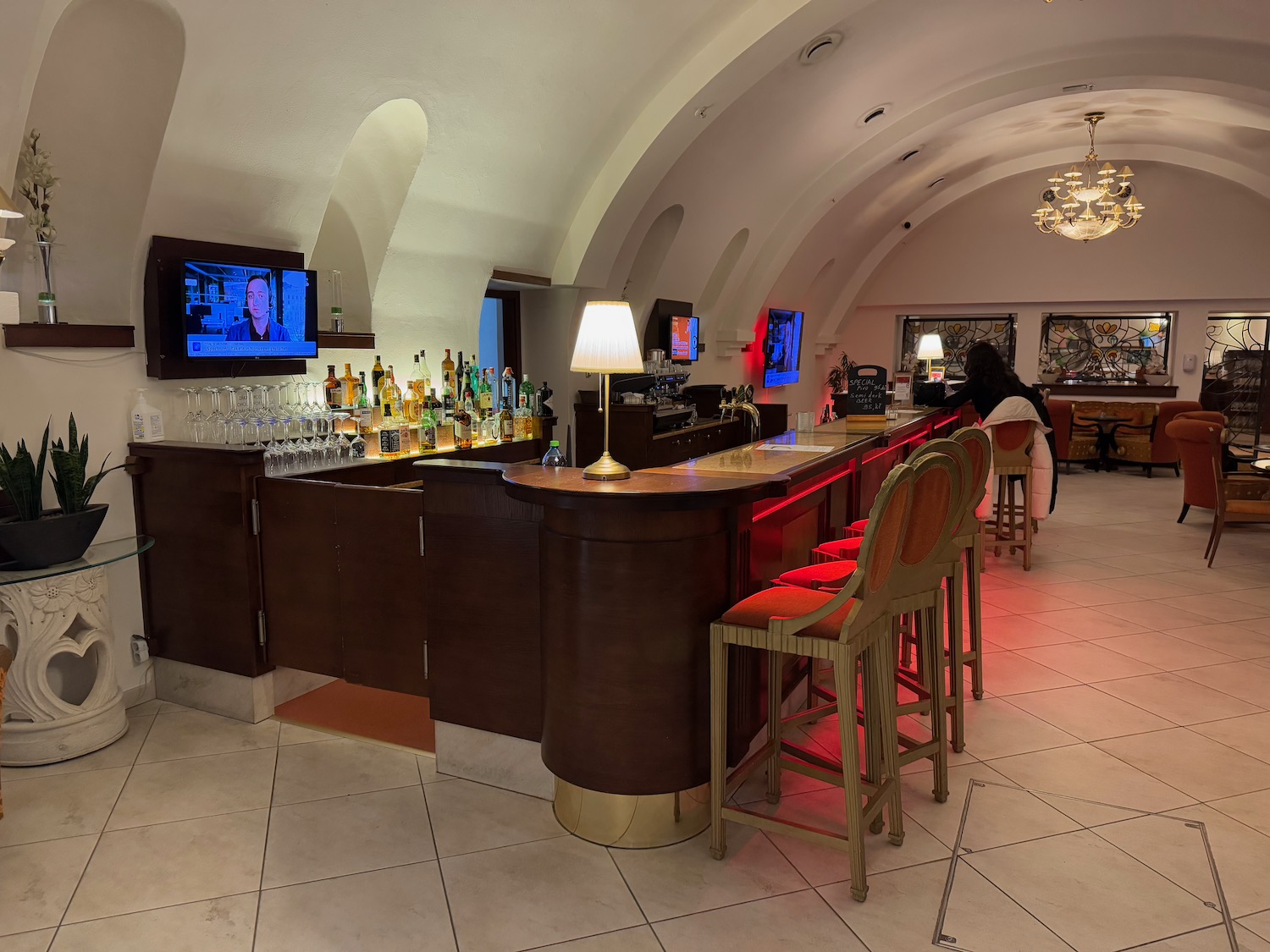 a bar with a row of chairs and a television