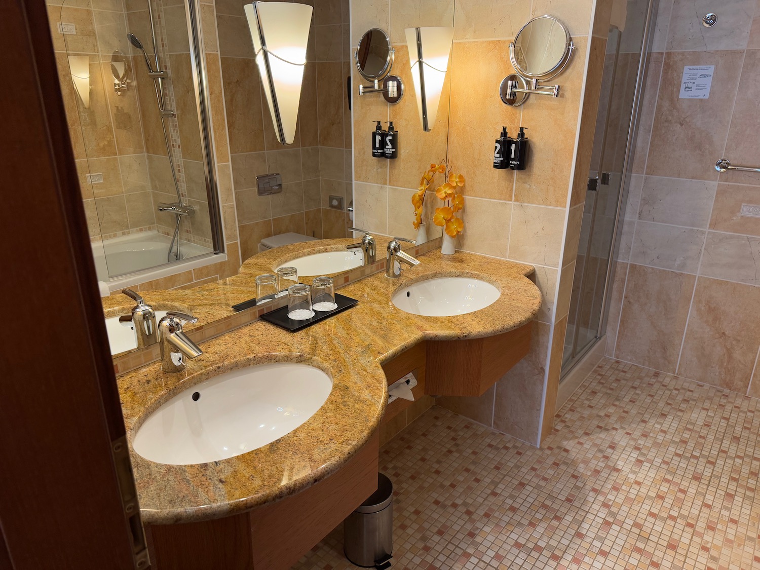 a bathroom with marble countertop sinks and shower