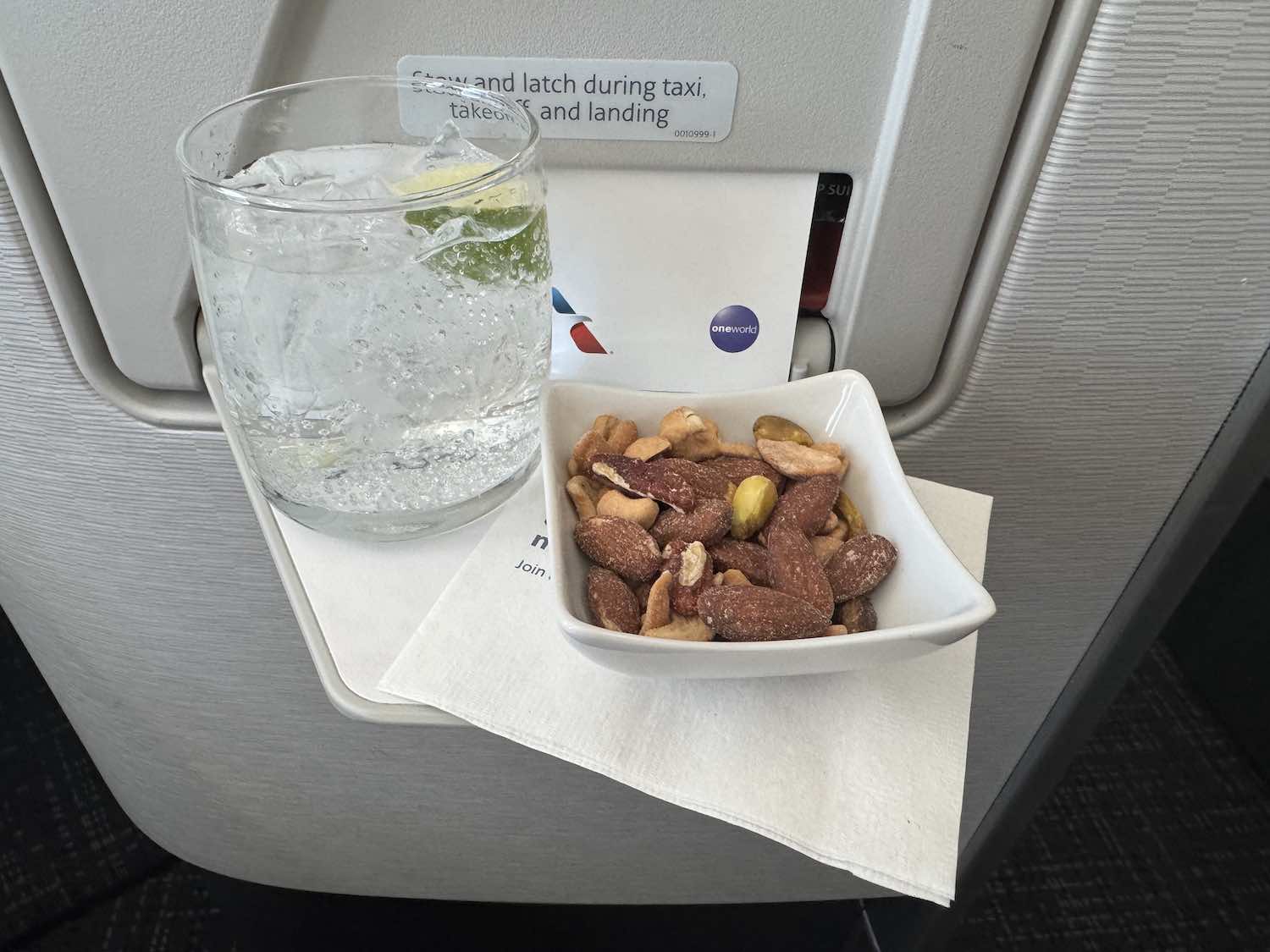 a bowl of nuts and a glass of water on a tray