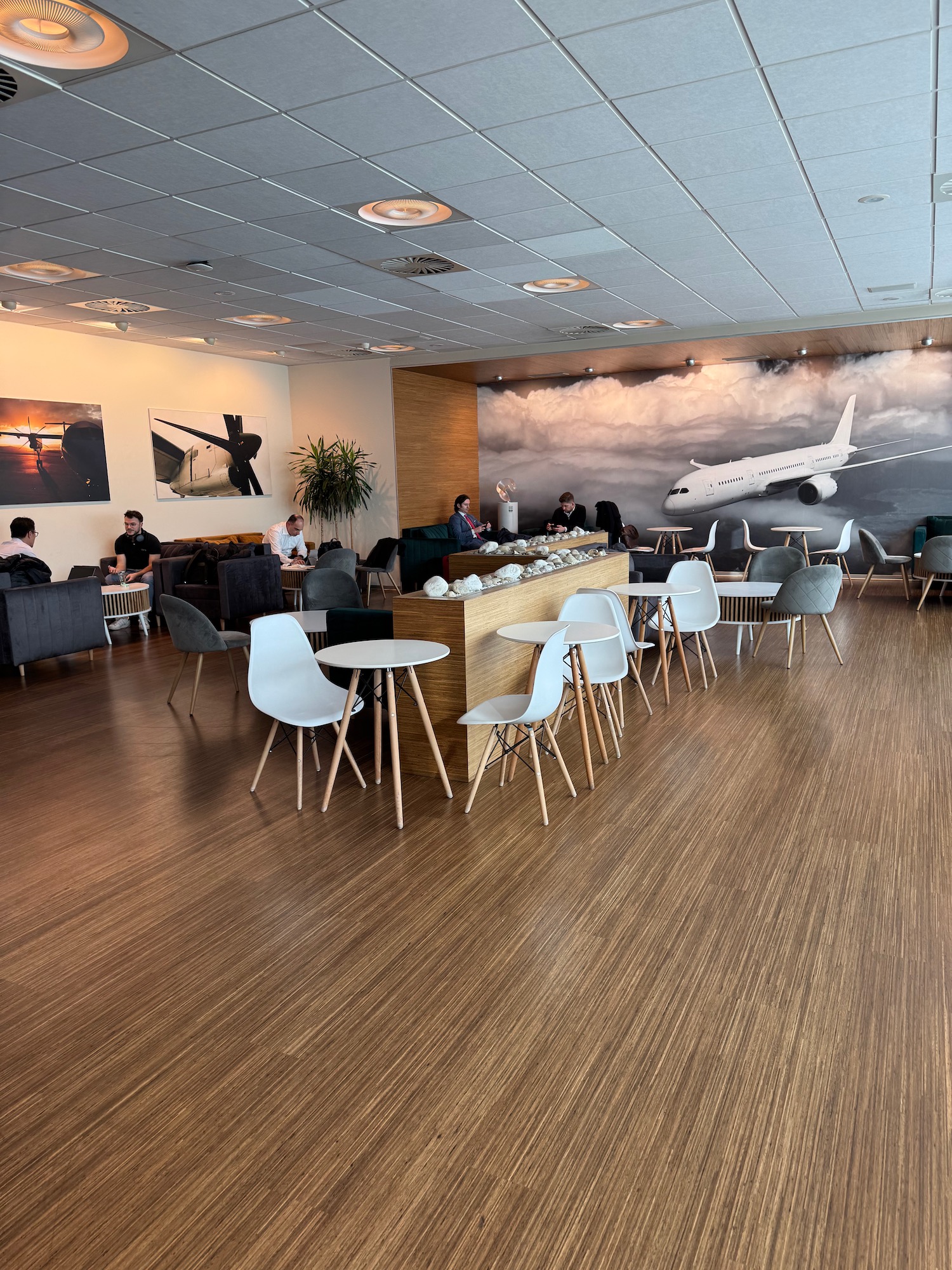 a room with tables and chairs and a large mural of an airplane