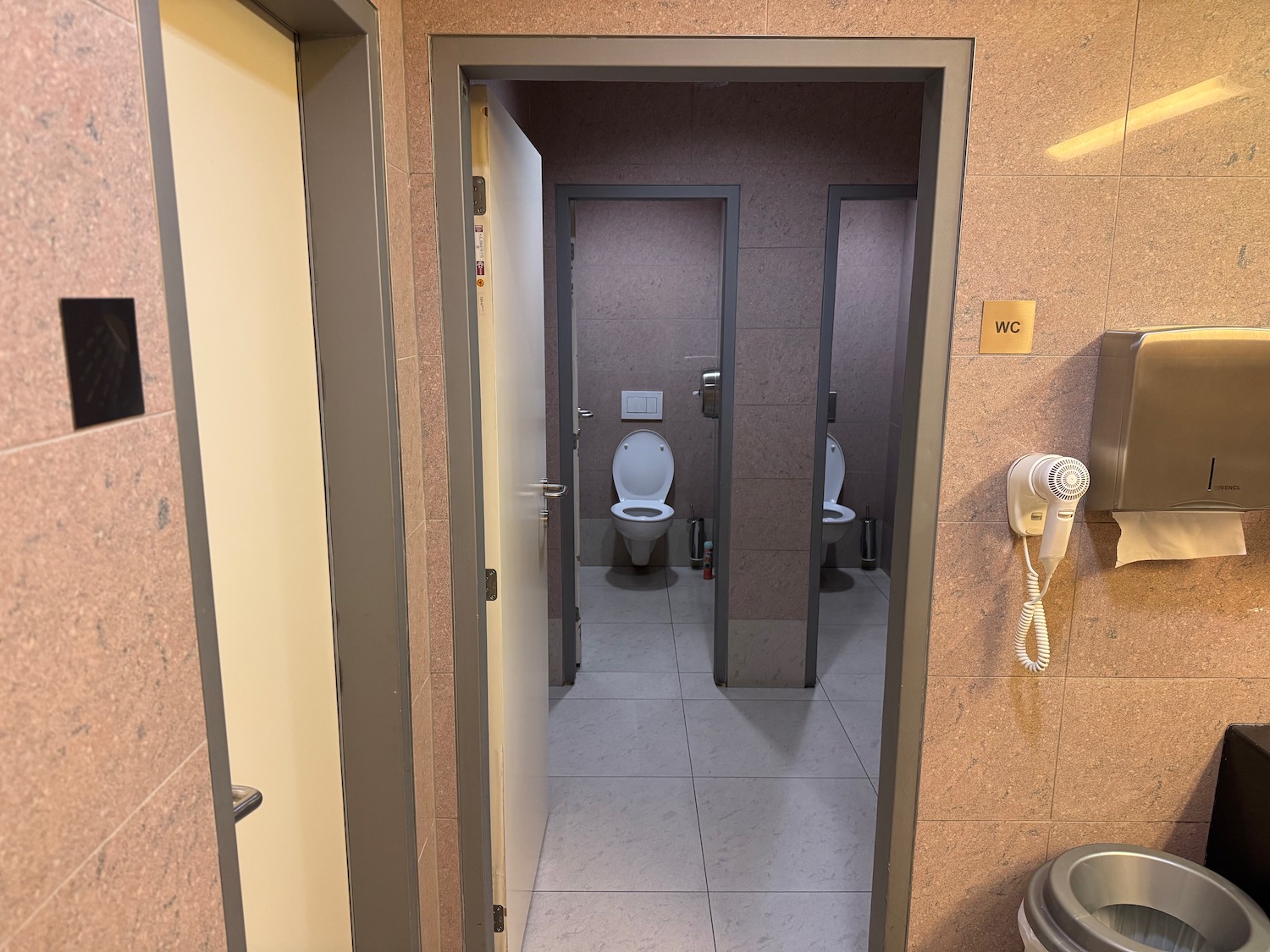 a bathroom with toilets and a toilet dryer