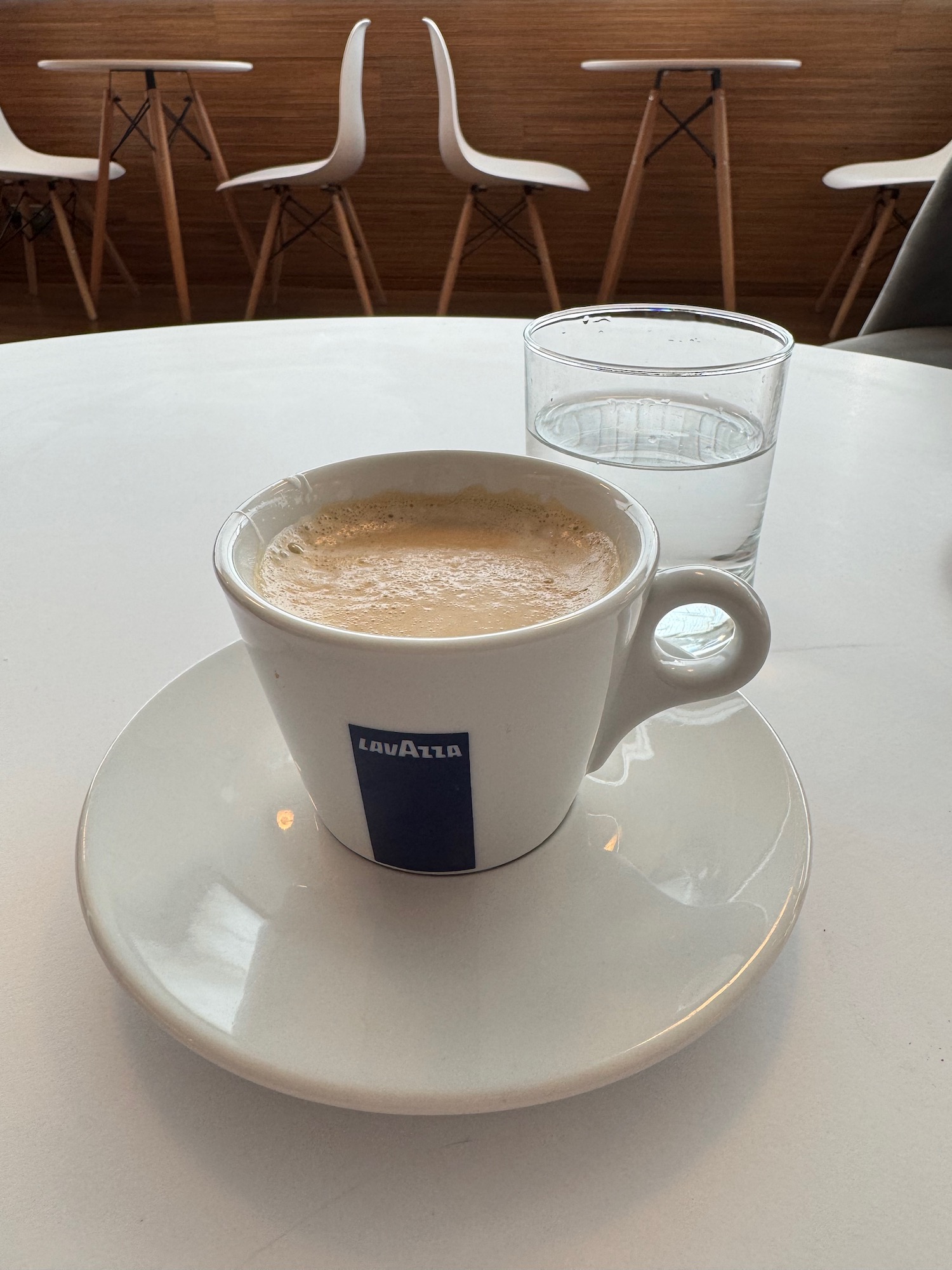 a cup of coffee and a glass of water on a white table