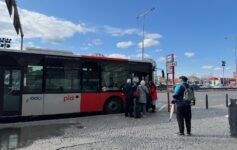 a group of people standing next to a bus