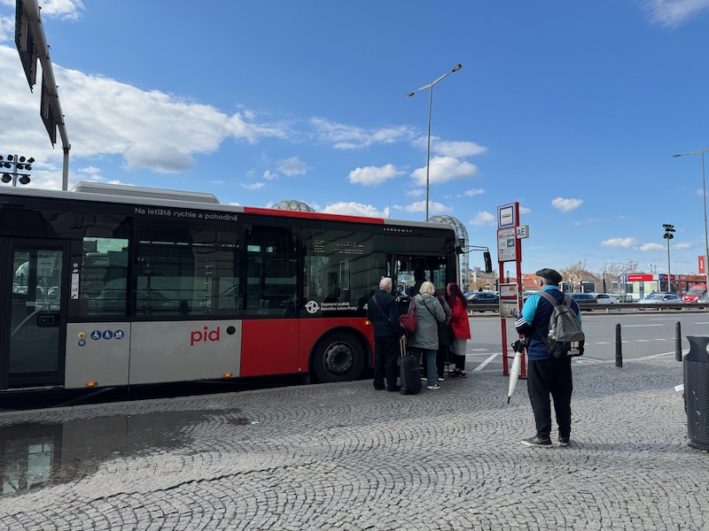 a group of people standing next to a bus