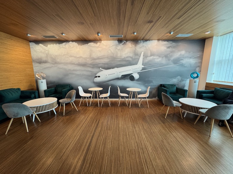 a room with a wall mural of an airplane and chairs