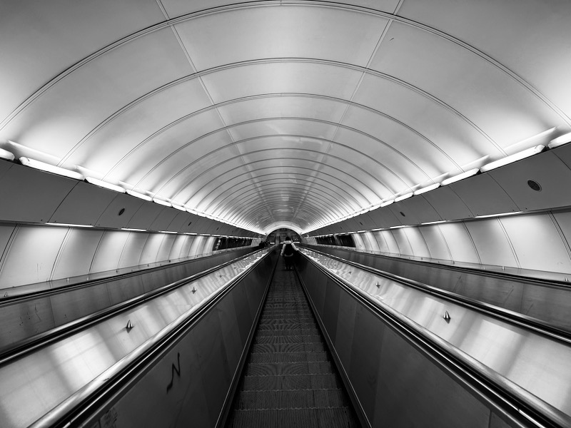 a black and white photo of a escalator