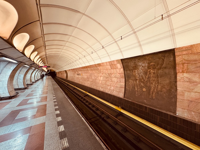 a subway station with a mural on the wall