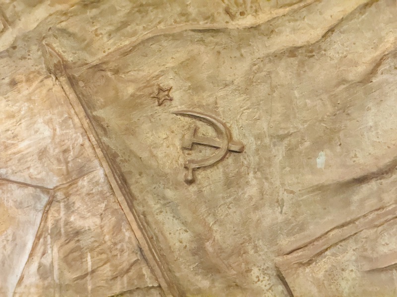a stone carving of a hammer and sickle